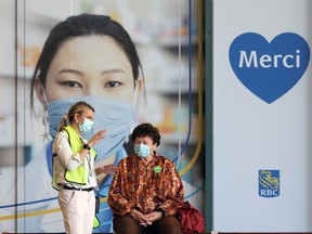 A woman is assisted outside the Covid-19 immunization clinic at RBC Convention Centre in Winnipeg on Sunday, May 9, 2021.