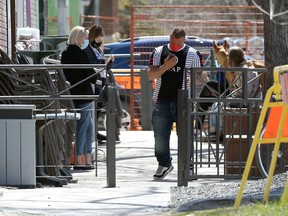 People wait for takeout orders on a Corydon Avenue patio in Winnipeg on Monday, May 10, 2021.