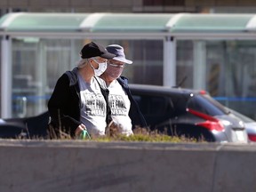 Two women wearing matching shirts reading 'The Peg, not for the weak, walk in the Osborne Village area of Winnipeg on Tuesday, May 11, 2021.