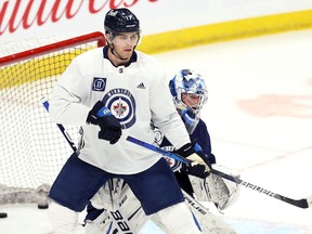 Adam Lowry sets up in front of goaltender Eric Comrie during Winnipeg Jets practice in Winnipeg on Monday, May 17, 2021.