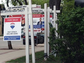 Real estate signs in front of a Corydon Avenue condominium in Winnipeg.