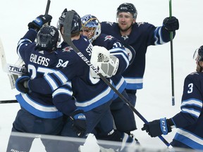 Winnipeg Jets forward Nikolaj Ehlers (left) is congratulated by Logan Stanley, Connor Hellebuyck, Neal Pionk and Tucker Poolman (from left) after his overtime goal against the Edmonton Oilers in Game 3 of a Stanley Cup playoff series in Winnipeg on Sunday, May 23, 2021.