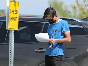 A person considers a consent form in the parking lot of the COVID-19 vaccination site on Leila Avenue in Winnipeg on Monday, May 24, 2021.