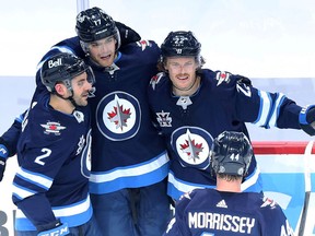 Winnipeg Jets forward Mason Appleton (left) is congratulated on his goal against the Edmonton Oilers in Game 4 of a Stanley Cup playoff series in Winnipeg by Dylan DeMelo, Adam Lowry and Josh Morrissey (from left) on Monday, May 24, 2021.