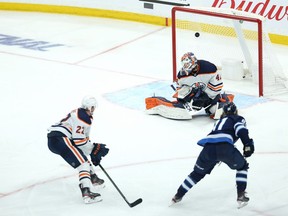 Winnipeg Jets forward Kyle Connor (right) beats Edmonton Oilers goaltender Mike Smith in triple overtime to sweep the best-of-seven Stanley Cup playoff series in Winnipeg on Monday, May 24, 2021.
