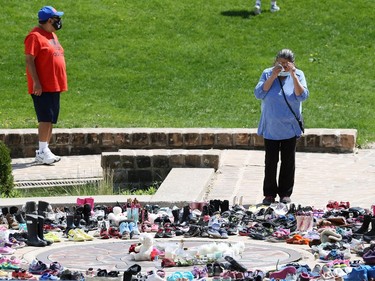 A woman is moved to tears looking at a memorial to the 215 children killed at a residential school in Kamloops, B.C., at the Oodena Circle at the Forks in Winnipeg, on Sunday, May 30, 2021.