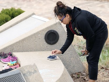 Sheila North, a candidate for grand chief of the Assembly of Manitoba Chiefs, with a pair of baby shoes to add to a memorial to the 215 children killed at a residential school in Kamloops, B.C., at the Oodena Circle at the Forks in Winnipeg, on Sunday, May 30, 2021.