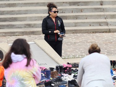 Sheila North, a candidate for grand chief of the Assembly of Manitoba Chiefs, with a pair of baby shoes to add to a memorial to the 215 children killed at a residential school in Kamloops, B.C., at the Oodena Circle at the Forks in Winnipeg, on Sunday, May 30, 2021.
