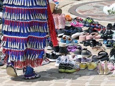 A woman in a jingle dress at a memorial to the 215 children killed at a residential school in Kamloops, B.C., at the Oodena Circle at the Forks in Winnipeg, on Sunday, May 30, 2021.