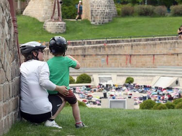 A woman speaks to a child near a memorial to the 215 children killed at a residential school in Kamloops, B.C., at the Oodena Circle at the Forks in Winnipeg, on Sunday, May 30, 2021.