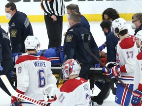 Montreal Canadiens centre Jake Evans is taken off the ice on a stretcher after being hit hard by Winnipeg Jets centre Mark Scheifele late  in Game 1.