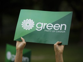 A supporter holds a sign for the Green Party of Canada as a group of candidates and supporters marched towards a discussion on climate with then leader Elizabeth May in Toronto, Tuesday, Sept. 3, 2019.