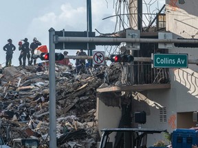 Members of the South Florida Urban Search and Rescue team look for possible survivors in the partially collapsed 12-story Champlain Towers South condo building in Surfside, Fla., Sunday, June 27, 2021.