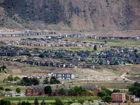 A general view of the former Kamloops Indian Residential School with housing developments on the mountain behind the school, where flowers and cards have been left to honour the 215 children whose remains have been discovered buried near the facility, in Kamloops, B.C., on June 3, 2021.