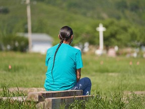 A man sits and prays at the field where the remains of over 750 children were buried on the site of the former Marieval Indian Residential School in Cowessess First Nation, Saskatchewan.