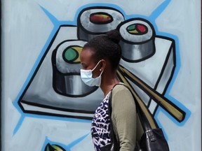 A person wears mask while walking in public in Winnipeg on Saturday.