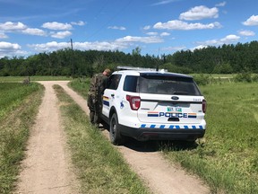 An RCMP officer at the rural property being searched in the RM of St. Clements, northeast of Winnipeg, on Tuesday, June 15, 2021. Mounties are searching the rural property in southern Manitoba for a homicide suspect they say is armed and dangerous and may have clothing and gear resembling that used by police.