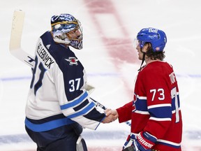 Montreal Canadiens Tyler Toffoli (right) shakes hands with Winnipeg Jets goalie Connor Hellebuyck following his game-winning goal in overtime during Game 4 at the Bell Centre on Monday night.