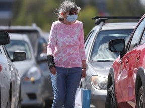 A person wears a mask while walking in a parking lot in Winnipeg on Tuesday, June 1, 2021.