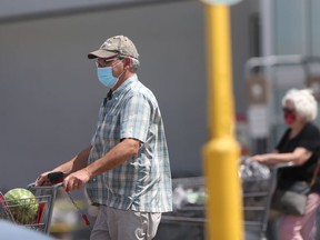 A person wears a mask while out running errands on Tuesday. Hospitalizations were reported to be relatively stable in Manitoba on Thursday.