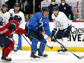 Andrew Copp (centre) is guarded by Neal Pionk (left) during Winnipeg Jets practice in Winnipeg on Mon., May 31, 2021. KEVIN KING/Winnipeg Sun/Postmedia Network