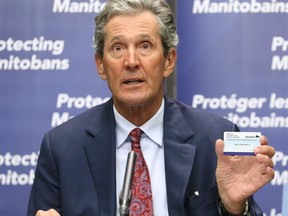 Premier Brian Pallister holds a vaccination card during a press briefing on vaccine measures at the Manitoba Legislative Building in Winnipeg on Tues., June 8, 2021. KEVIN KING/Winnipeg Sun/Postmedia Network