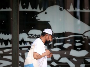 A person walks past art in the window of The Bay in downtown Winnipeg on Friday, June 11, 2021.