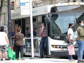 A man holds his mask as he steps off a transit bus in downtown Winnipeg on Wed., June 16, 2021. KEVIN KING/Winnipeg Sun/Postmedia Network