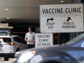 A man wearing a COVID-19 vaccination sticker walks outside RBC Convention Centre in Winnipeg on Sunday, June 20, 2021.