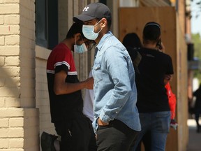 People wait to enter a building on William Avenue in Winnipeg on Tuesday, June 22, 2021.