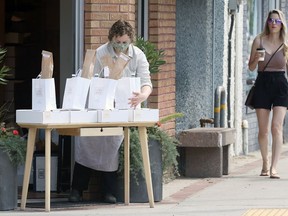 Pickup orders are placed outside The Cheesemongers Fromagerie on Corydon Avenue in Winnipeg on Thursday. Restaurants will return to inside service on Saturday.