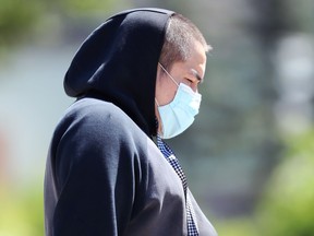 A man wearing a mask walks along Main Street in Winnipeg on Monday, June 28, 2021.