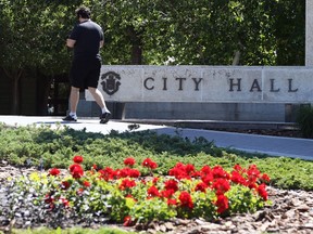 A man wearing a mask approaches City Hall in Winnipeg on Monday, June 28, 2021.