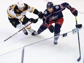 Jack Studnicka (68) of the Boston Bruins slows down Riley Nash (20) of the Columbus Blue Jackets during the first period in an exhibition game prior to the 2020 NHL Stanley Cup Playoffs at Scotiabank Arena on July 30, 2020 in Toronto.