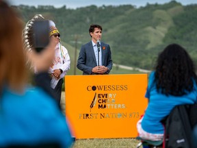 Prime Minister Justin Trudeau speaks during a ceremony at the site of a former residential school where small flags are placed in spots of unmarked graves, in Cowessess First Nation, Sask, July 6, 2021.