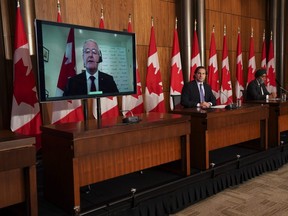 Immigration Minister Marco Mendicino, cente, is joined by Harjit Sajjan, Minister of National Defence and virtually by Marc Garneau, Minister of Foreign Affairs, during press conference in Ottawa on Friday, July 23, 2021. The federal government says it will fast-track the resettlement of Afghans who previously worked with the Canadian military and embassy and are now at risk from the Taliban.