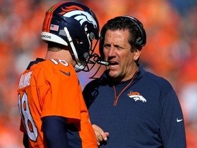 Peyton Manning, left, of the Denver Broncos speaks to offensive coordinator Rick Dennison in the first half against the New England Patriots in the AFC Championship game at Sports Authority Field at Mile High on Jan. 24, 2016 in Denver.