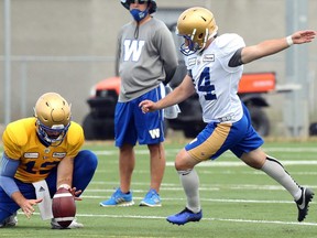 Quarterback Sean McGuire holds for kicker Tyler Crapigna during Winnipeg Blue Bombers practice on the University of Manitoba campus in Winnipeg on July 21, 2021.