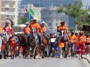 A large group of people, many dressed in orange, walked along Portage Avenue in Winnipeg today.  The contingent was one of several events intended to have the Indian Residential School experience recognized as a genocide. Saturday, July 01, 2/2021.Winnipeg Sun/Chris Procaylo/stf
