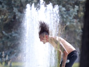 A person cools off near a fountain in Winnipeg on Saturday, July 10, 2021.