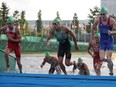 Tyler Mislawchuk of Canada, Joao Silva of Portugal and Oscar Coggins of Hong Kong run out of water during the Tokyo 2020 Olympics Men's Triathlon at Odaiba Marine Park in Tokyo, on July 26, 2021.