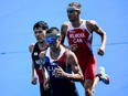 France's Vincent Luis (centre), Japan's Kenji Nener (left) and Canada's Tyler Mislawchuk compete in the men's individual triathlon competition during the Tokyo 2020 Olympic Games at the Odaiba Marine Park in Tokyo on July 26, 2021.