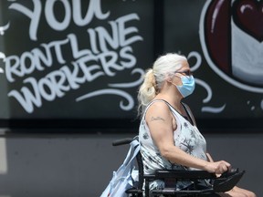 A person wears a mask while using a mobility device in Winnipeg on Saturday, July 3, 2021.