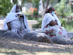 Two people wear masks while relaxing in a park in Winnipeg.  Wednesday, July 14/2021.Winnipeg Sun/Chris Procaylo/stf