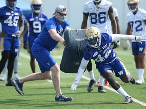 Cornerback Deatrick Nichols (right) is blocked by head coach Mike O'Shea during a drill at Winnipeg Blue Bombers training camp on the University of Manitoba campus in Winnipeg on Sunday, July 18, 2021.