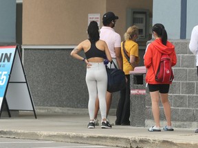 People wait to enter a Pembina Highway fitness centre in Winnipeg on Monday, July 19, 2021.