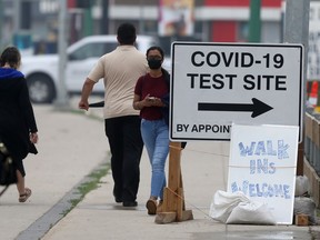 People walk past a COVID-19 test site in Winnipeg on Wednesday afternoon.  Chris Procaylo/Winnipeg Sun