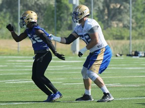 Offensive lineman Geoff Gray (right) grabs hold of defensive back DeAundre Alford during Winnipeg Blue Bombers training camp on the University of Manitoba campus in Winnipeg on Sunday, July 25, 2021.