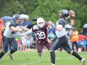 Winnipeg Rifles quarterback Bryson McNeil (right) throws in the rain while being persued by Regina Thunder defender Reed Rabbetz in CJFL action at Maple Grove Park in Winnipeg. Matthew Hamilton/Winnipeg Rifles