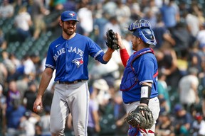 Toronto Blue Jays relief pitcher Jordan Romano (left) high-fives catcher Alejandro Kirk following a victory against the Seattle Mariners.
